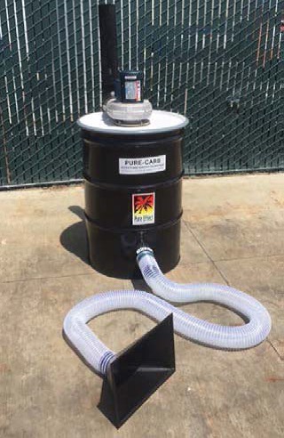 A black Pure Effect smoke-and-odor carbon drum with a flexible hose intake on pavement