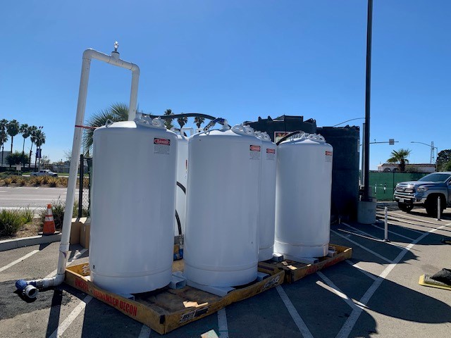 Three white Pure Effect liquid-phase granular-activated-carbon vessels staged on a wooden pallet