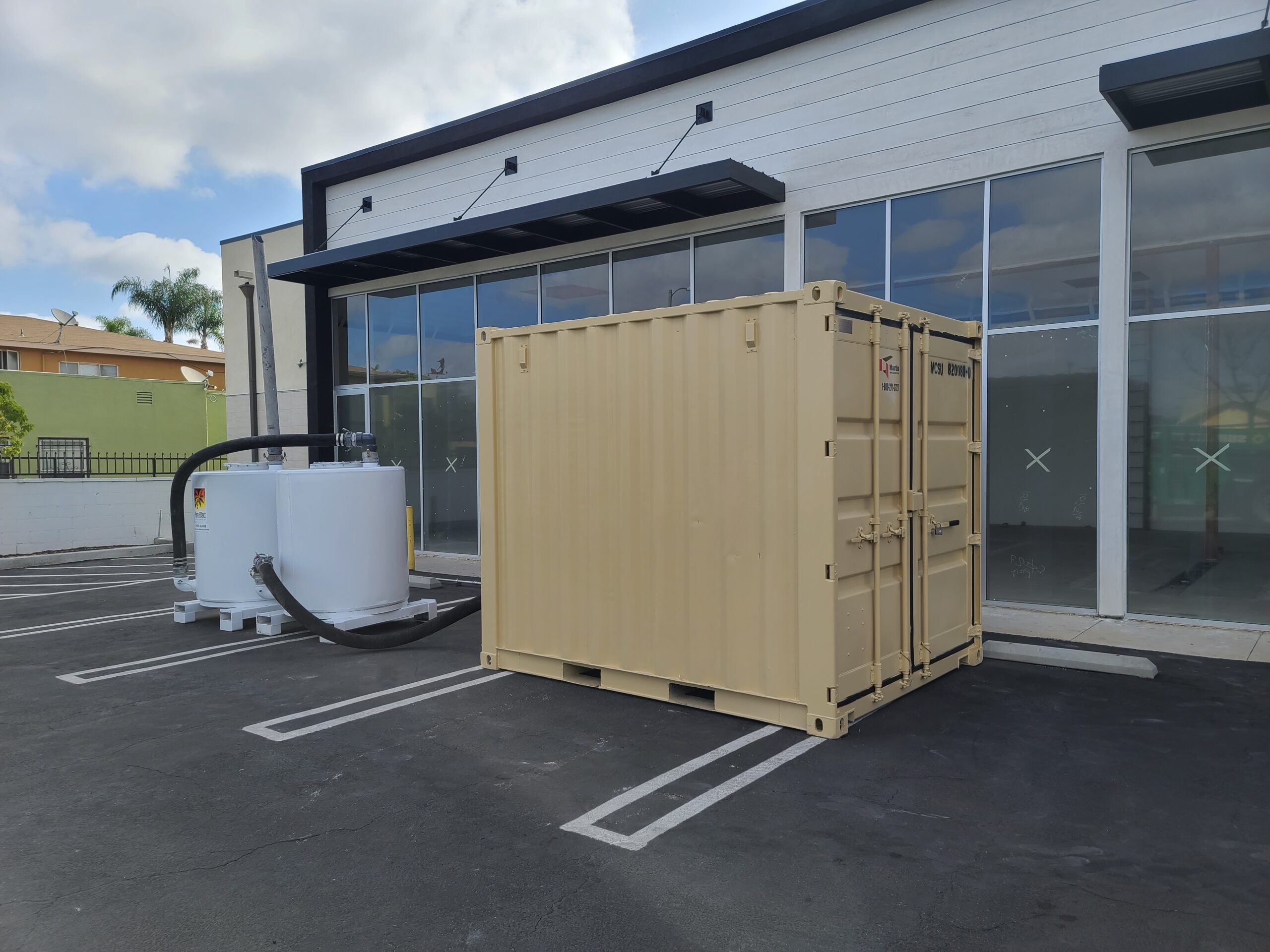 White Pure Effect carbon vessels beside a shipping container in the parking lot of a commercial building