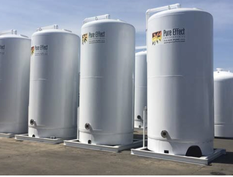 A clean row of white branded Pure Effect carbon vessels on skids against a blue sky, used for PFAS treatment